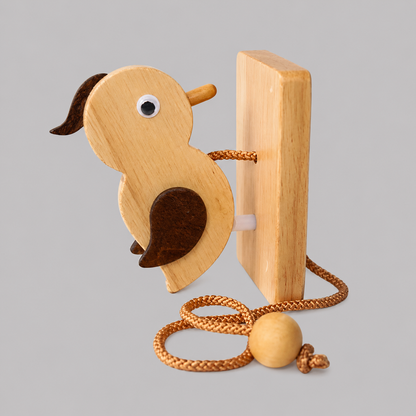 Wooden woodpecker door knocker close-up with metal eye, striker plate, and cord